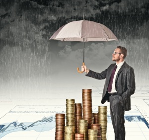 businessman cover his money with umbrella